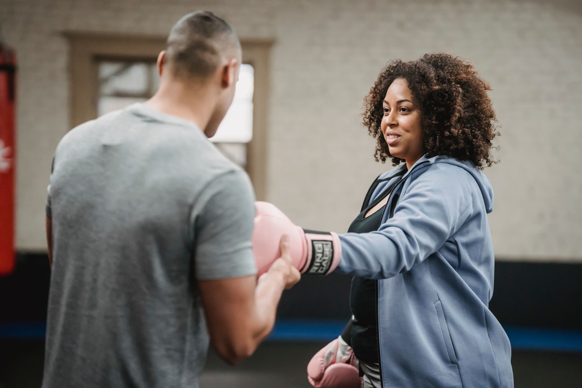 Mujer entrenando boxeo en gimnasio para perder peso