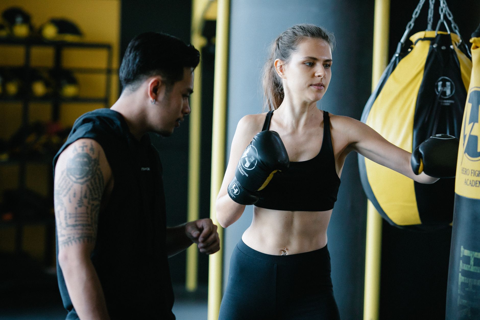 Clase de boxeo en gimnasio con sacos y alumnos entrenando