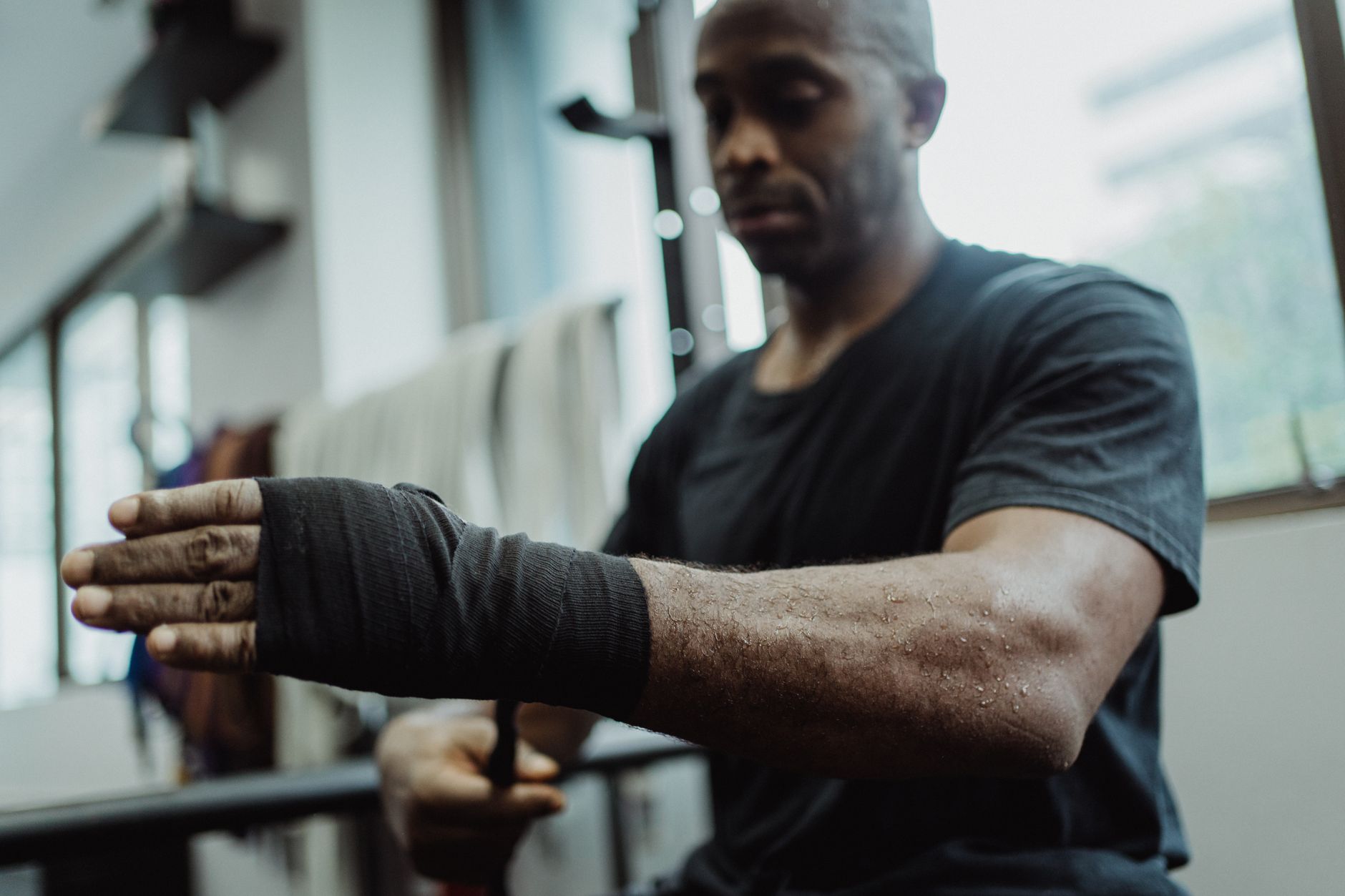 Boxeador vendándose las manos antes de entrenar en un gimnasio de pueblo